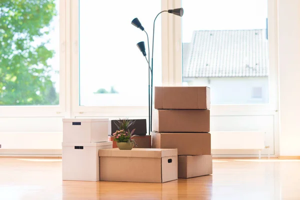 De nombreuses boîtes en carton dans une maison lumineuse lors de la relocalisation — Photo