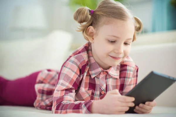 Całkiem mała dziewczynka dziecko przy użyciu cyfrowego tabletu, patrząc i sm — Zdjęcie stockowe