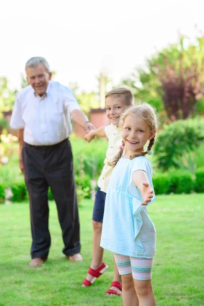 Portrait of happy old grandfather and cute children — Stock Photo, Image
