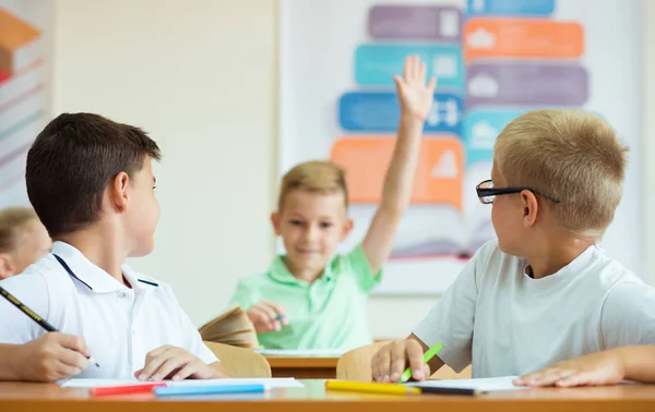 Porträtt av skolpojke lyfter sin hand på lektionen — Stockfoto