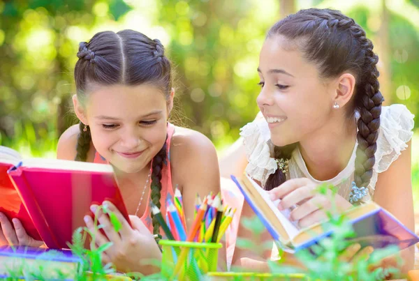 Meninas hispânicas felizes desenhando e estudando no parque — Fotografia de Stock