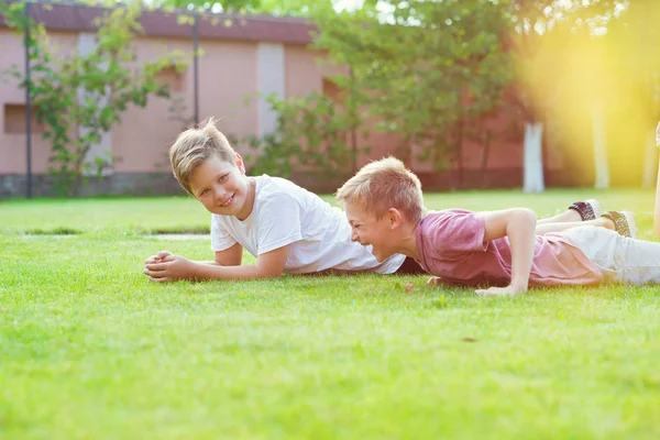İki çocuk okul bahçesinde futbol oynarken eğleniyor