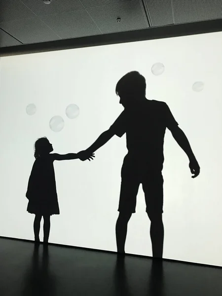Siluetas de un niño y una niña tomados de la mano — Foto de Stock
