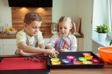 İki mutlu çocuk Noel pişirme kurabiye ve kek kitch,