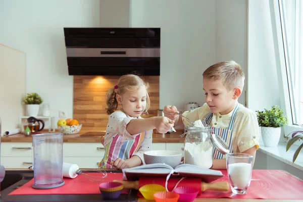 Due bambini felici piccoli e carini che preparano muffin in k moderno — Foto Stock