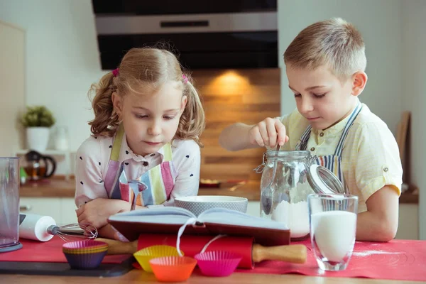 Due bambini felici piccoli e carini che preparano muffin in k moderno — Foto Stock