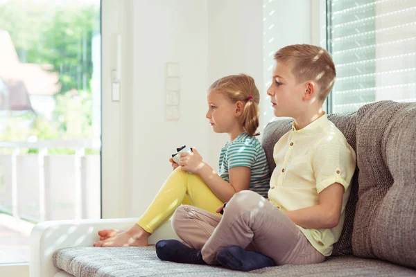 Two happy children playing video games at home — Stock Photo, Image