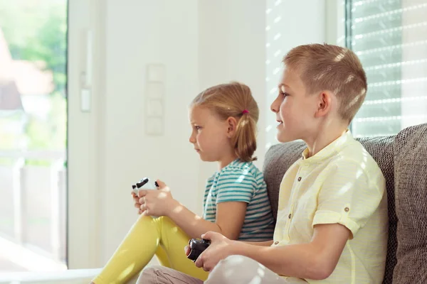 Duas crianças felizes jogando videogames em casa — Fotografia de Stock