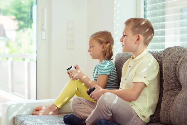 Δύο χαρούμενα παιδιά που παίζουν βιντεοπαιχνίδια στο σπίτι — Φωτογραφία Αρχείου