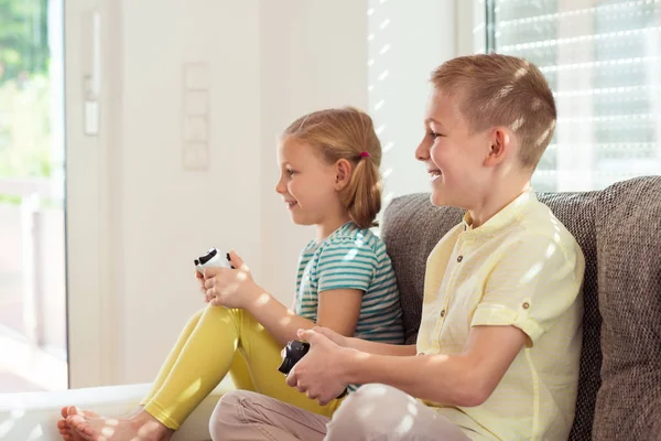 Δύο χαρούμενα παιδιά που παίζουν βιντεοπαιχνίδια στο σπίτι — Φωτογραφία Αρχείου