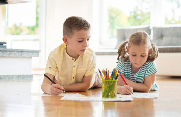 Dos lindos niños dibuja con lápices de colores en casa — Foto de Stock