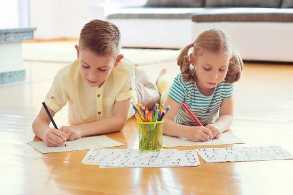 Deux enfants mignons dessinent avec des crayons colorés à la maison — Photo