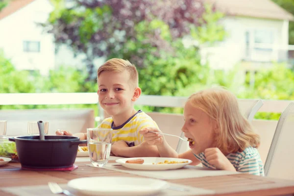 Zwei glückliche kleine Kinder beim gesunden Frühstück zu Hause — Stockfoto