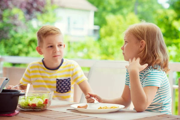 Due bambini felici mangiano una colazione sana a casa — Foto Stock