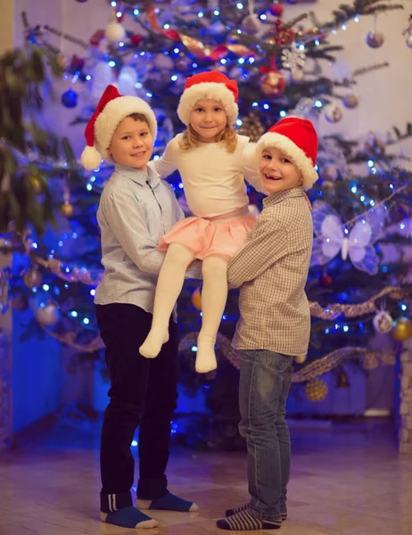 Portrét tří šťastných dětí baví na Štědrý den — Stock fotografie