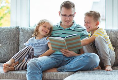 Genç mutlu okuma kitabı evde sevimli çocukla Peder.