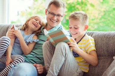 Genç mutlu okuma kitabı evde sevimli çocukla Peder.