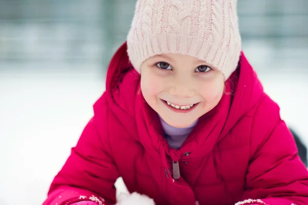 Porträtt av glad söt liten tjej plainf med snö på vintern — Stockfoto