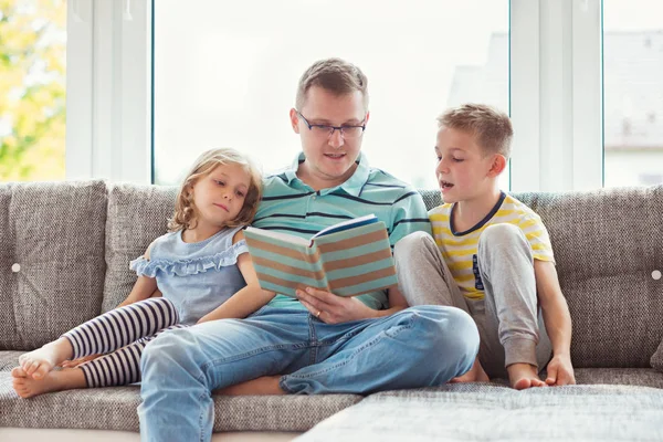 Jeune père heureux livre de lecture avec des enfants mignons à la maison — Photo