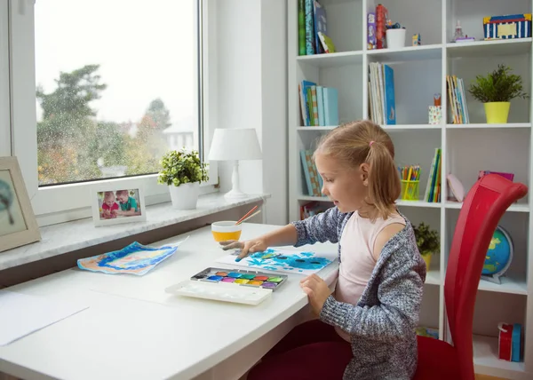 Hübsches kleines Mädchen malt zu Hause mit bunter Farbe — Stockfoto