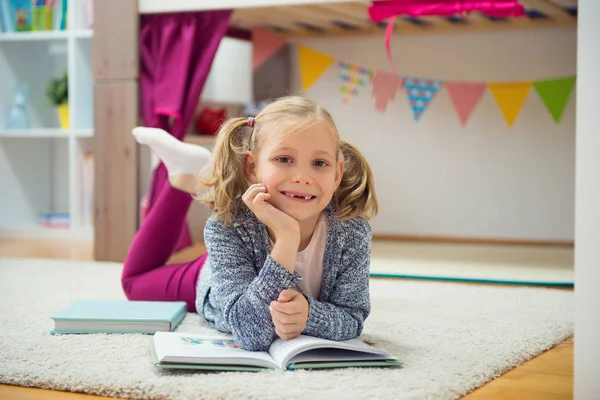 Söt liten flicka läsa bok hemma — Stockfoto