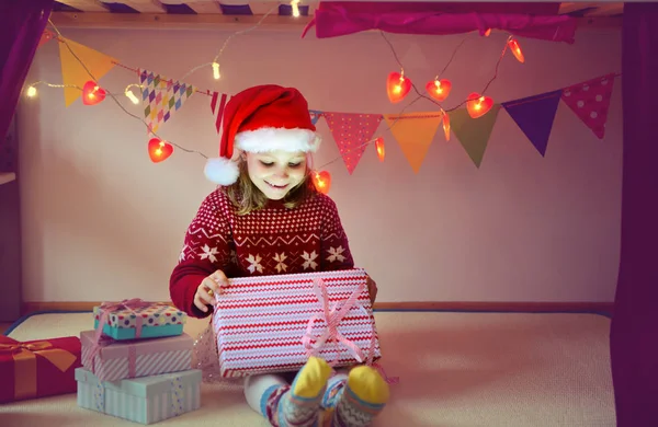 Niedliches Mädchen öffnet Schachtel mit Weihnachtsgeschenk — Stockfoto