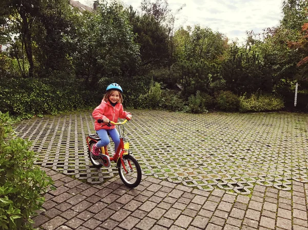 Glada lilla barn ridning på cykel och hjälm på bakgården — Stockfoto