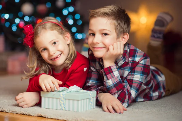 Двое счастливых детей в новогоднюю ночь с подарками рядом с Новым годом T — стоковое фото