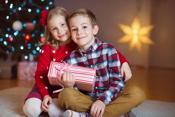 Двоє щасливих дітей напередодні Нового року з подарунками біля Нового року Т — стокове фото