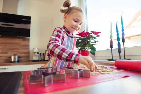 Досить маленька дівчинка зі смішними кісками, що роблять різдвяне печиво — стокове фото