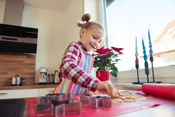 Menina bonita com tranças engraçadas fazendo biscoitos de Natal — Fotografia de Stock