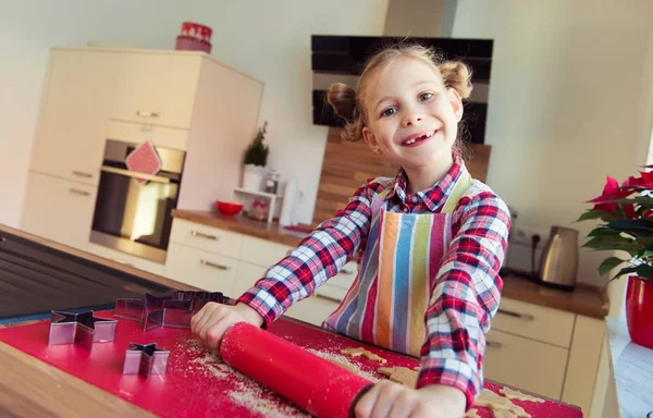 Hübsches kleines Mädchen mit lustigen Zöpfen, die Weihnachtsplätzchen backen — Stockfoto
