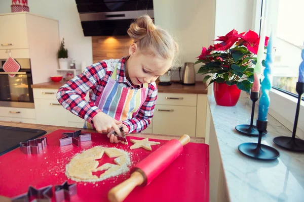 Hübsches kleines Mädchen mit lustigen Zöpfen, die Weihnachtsplätzchen backen — Stockfoto