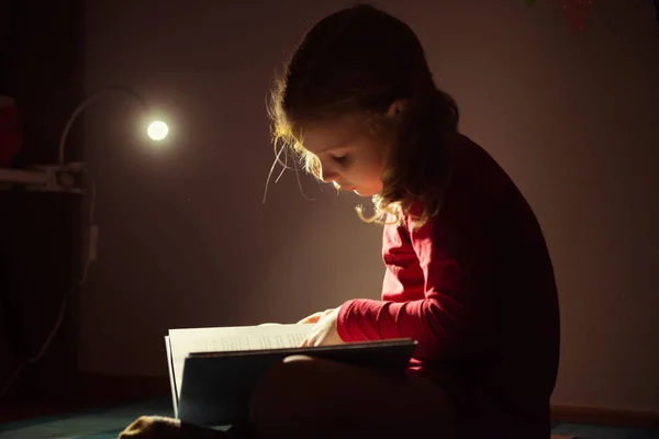 Menina bonita lendo livro em seu esconderijo com flashli — Fotografia de Stock