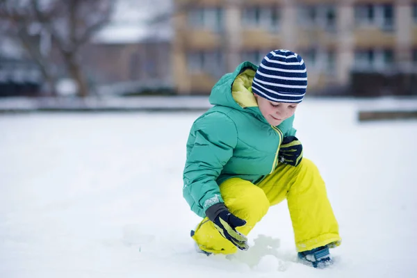 Portrait de petit garçon jouant avec la neige en hiver — Photo