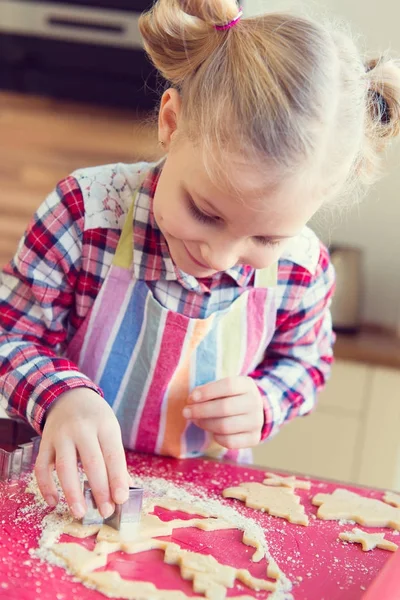 Menina bonita com tranças engraçadas fazendo biscoitos de Natal — Fotografia de Stock