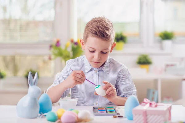 Menino feliz se divertindo durante a pintura de ovos para a Páscoa em sp — Fotografia de Stock