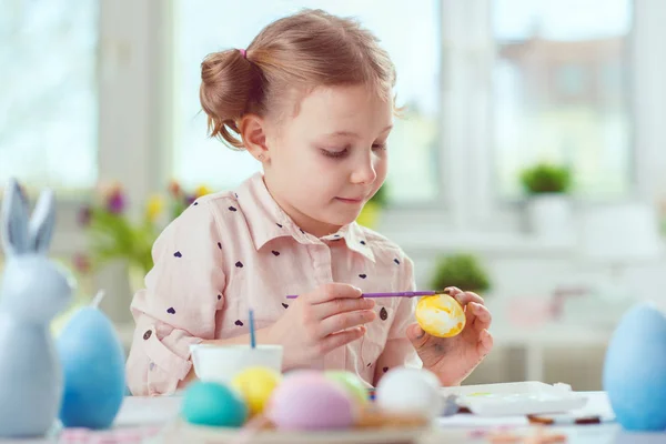 Joyeux joli enfant fille avoir du plaisir pendant la peinture des œufs pour l'Est — Photo