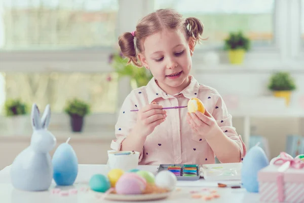 Šťastné dítě hezká dívka baví během malování vajíček pro východ — Stock fotografie