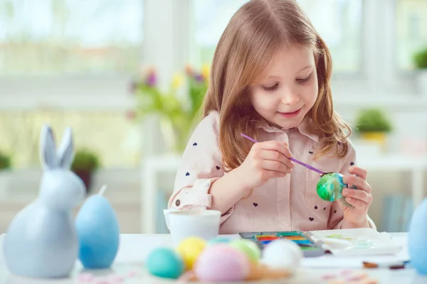 Šťastné dítě hezká dívka baví během malování vajíček pro východ — Stock fotografie