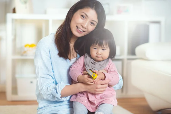 Ritratto di una bella madre giapponese che tiene il suo bambino carino daugh — Foto Stock