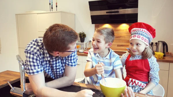 Giovane padre con due bambini felici che sostengono i biscotti nella k moderna — Foto Stock