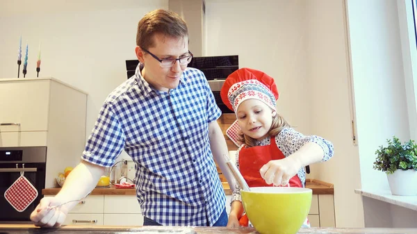 Jovem pai com filha bonita apoiando biscoitos e hav — Fotografia de Stock