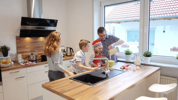 Счастливая молодая семья готовит и веселится по утрам в kitc — стоковое фото