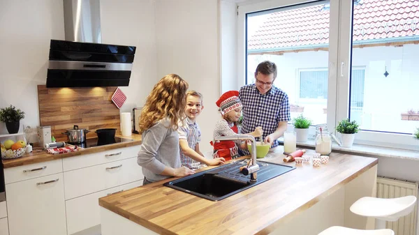 Feliz joven familia cocinando y divirtiéndose en la mañana en kitc — Foto de Stock
