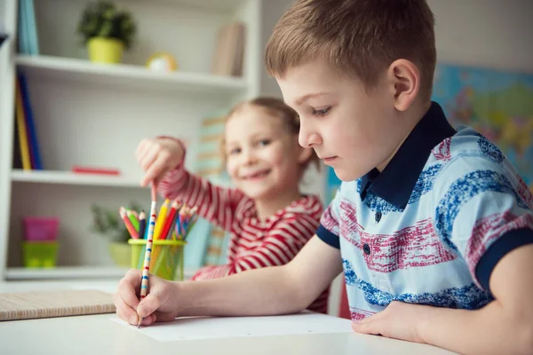 Due simpatici bambini che disegnano con matite colorate — Foto Stock