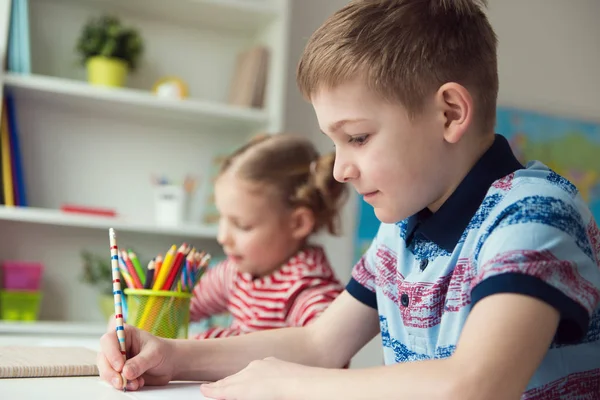 Dos lindos niños dibujando con lápices de colores — Foto de Stock