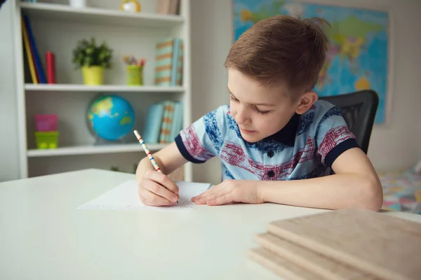 Mały chłopiec szkoły smart Dokonywanie domowe w biurko w pokoju — Zdjęcie stockowe