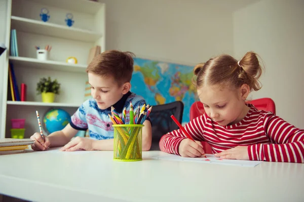 Два милых ребенка рисуют красочными карандашами — стоковое фото