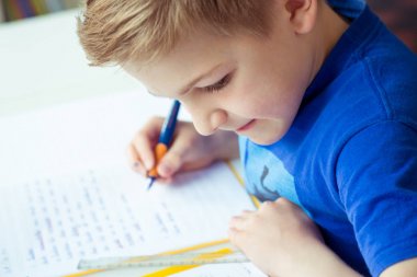 Akıllı çocuk ev ödevi odasında yapar.